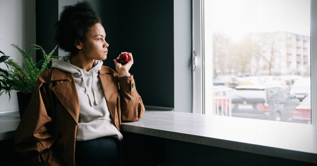 Person sitting by a window in Ottawa during winter, illustrating seasonal low mood and the winter blues.