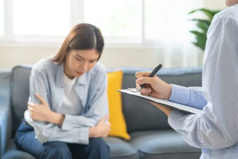 Depression Therapy. Psychology, depression. A suffering Asian young woman is in consultation with a psychologist while receiving patient counselling and mental therapy, with a doctor taking notes at the clinic. A psychologist with a person with poor mental health.